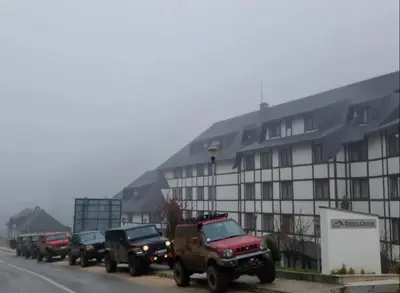 a row of trucks parked on a street next to a building at Apartman Aleksandar AS in Brzeće