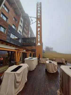 a building with white tables and a sign on it at Apartman Aleksandar AS in Brzeće