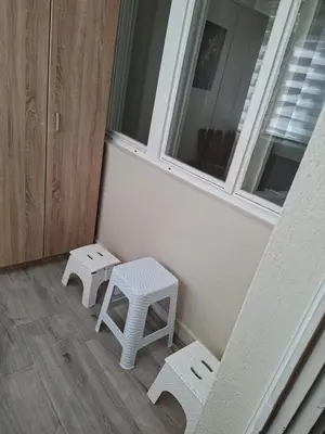 a room with two white stools and a window at Apartman Pesic Niš in Niš