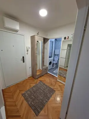 a hallway with a room with a toilet and a mirror at Apartman Pesic Niš in Niš