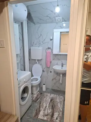 a bathroom with a toilet sink and a washing machine at Apartman Pesic Niš in Niš