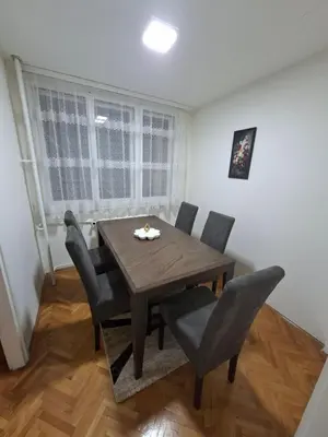 a dining room with a wooden table and chairs at Apartman Pesic Niš in Niš