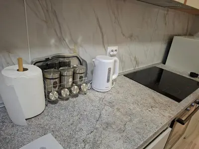 a kitchen counter with a coffee maker and jars on it at Apartman Pesic Niš in Niš