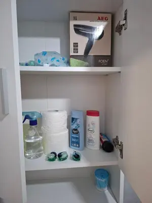 a bathroom shelf with toiletries and a box on it at Apartman Pesic Niš in Niš