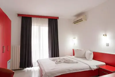 a bedroom with a red and white bed and a window at Apartmani Šumadija 17 in Vrnjačka Banja