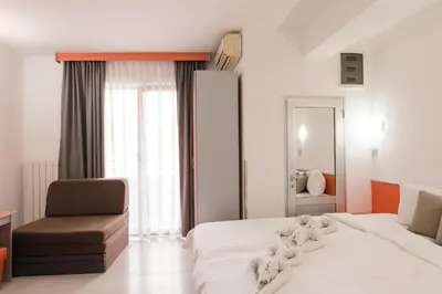 a hotel room with a bed and a chair at Apartmani Šumadija 17 in Vrnjačka Banja