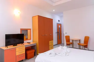 a bedroom with a bed with a tv and a cabinet at Apartmani Šumadija 17 in Vrnjačka Banja