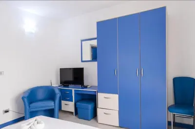 a room with a blue cabinet and two blue chairs at Apartmani Šumadija 17 in Vrnjačka Banja