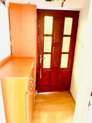 a kitchen with a red door and a wooden floor at Apartman Aki in Vlasotince