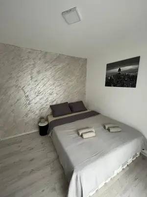 a white bedroom with a large bed with two towels at Golding Lux in Soko Banja