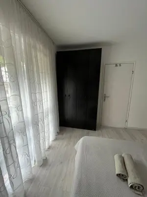 a white bedroom with a bed and a black door at Golding Lux in Soko Banja