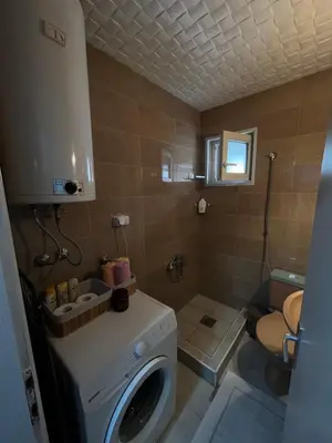 a bathroom with a washing machine and a toilet at Golding Lux in Soko Banja
