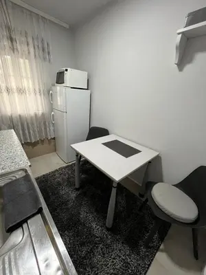 a white table and chairs in a room with a refrigerator at Golding Lux in Soko Banja