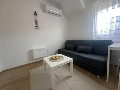 a living room with a blue couch and a table at Tesla centar free parking in Vranje