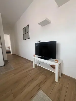 a living room with a flat screen tv on a white wall at Tesla centar free parking in Vranje
