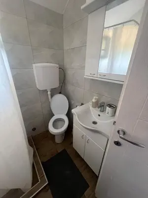 a white bathroom with a toilet and a sink at Tesla centar free parking in Vranje