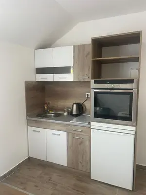 a kitchen with white cabinets and a sink and a microwave at Tesla centar free parking in Vranje