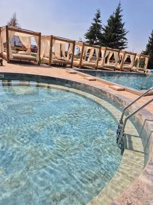 a large swimming pool with a wooden fence around it at Residence Hill - Apartman B112A in Kopaonik
