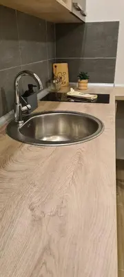 a sink in a kitchen with a wooden counter top at Residence Hill - Apartman B112A in Kopaonik