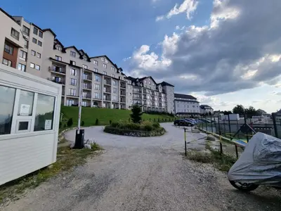 an empty parking lot in front of a building at Kopaonik, Milmari resort, Apartman Duga in Kopaonik