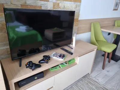 a living room with a television and a green chair at Kopaonik, Milmari resort, Apartman Duga in Kopaonik