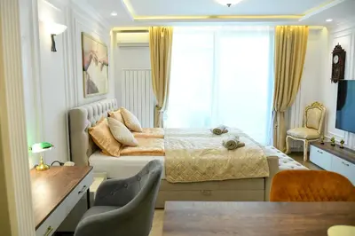 a bedroom with a bed and a table and chairs at Residence LUX in Niš