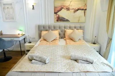 a bedroom with a bed with two pillows on it at Residence LUX in Niš