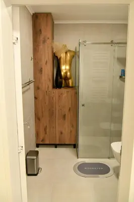 a bathroom with a shower and a vase on a cabinet at Residence LUX in Niš