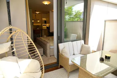 a living room with a chair and a glass table at Residence LUX in Niš