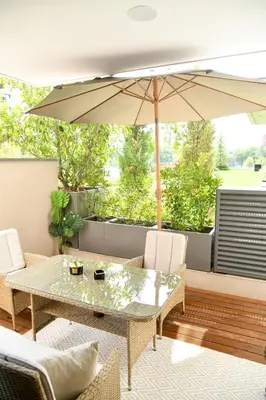 a patio with a table and an umbrella at Residence LUX in Niš