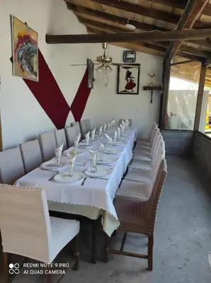 a long table with white tables and chairs in a room at Etno Deša Apartmani in Dimitrovgrad