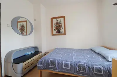 a bedroom with a bed and a dresser and a mirror at Etno Deša Apartmani in Dimitrovgrad