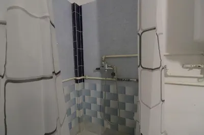 a bathroom with a shower with blue tiles on the wall at Etno Deša Apartmani in Dimitrovgrad