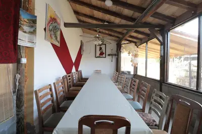 a long table in a room with chairs at Etno Deša Apartmani in Dimitrovgrad