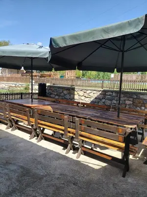 a group of benches sitting under umbrellas at Etno Deša Apartmani in Dimitrovgrad