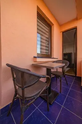 a table and chairs in a room with a window at Apartman ANJA LUX01 in Pirot