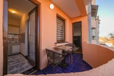 a balcony with a table and chairs on a building at Apartman ANJA LUX01 in Pirot