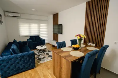 a living room with a table and a blue couch at Lilys LUX apartman in Vrnjačka Banja