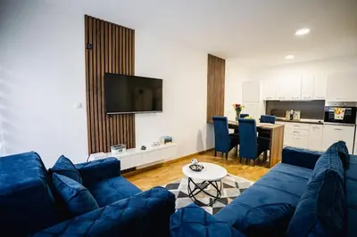a living room with a blue couch and a table at Lilys LUX apartman in Vrnjačka Banja