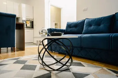 a living room with a blue couch and a table at Lilys LUX apartman in Vrnjačka Banja