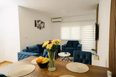 a living room with a table with a vase of flowers at Lilys LUX apartman in Vrnjačka Banja