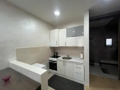 a small kitchen with white cabinets and a sink at Sofija apartmani in Paraćin