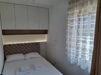 a bedroom with a bed with white cabinets and a window at Kopaonik,President kop Katarina free wellness&spa in Kopaonik