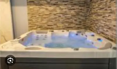 a jacuzzi tub in a room with a stone wall at Kopaonik,President kop Katarina free wellness&spa in Kopaonik