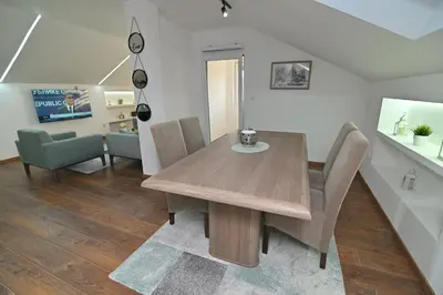 a dining room with a wooden table and chairs at Lux&Spa Petko in Pirot