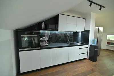 a kitchen with white cabinets and black counter tops at Lux&Spa Petko in Pirot