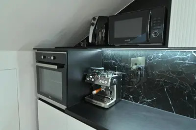 a black counter with a tv and a machine on it at Lux&Spa Petko in Pirot