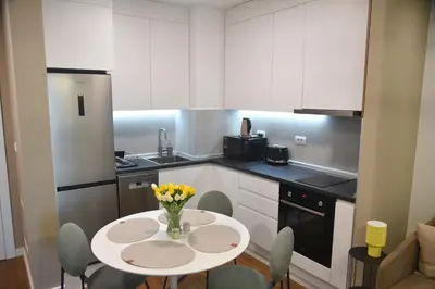 a kitchen with a table with flowers on it at Urban Elegance SPA Studio in Niš