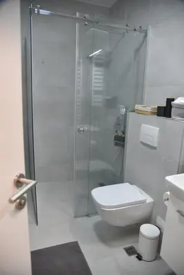 a bathroom with a toilet and a glass shower at Urban Elegance SPA Studio in Niš