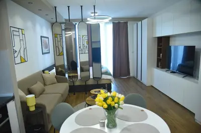 a living room with a couch and a table with flowers at Urban Elegance SPA Studio in Niš